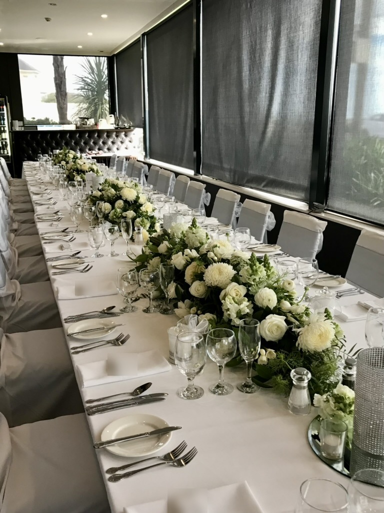Long reception table with white flower garlands