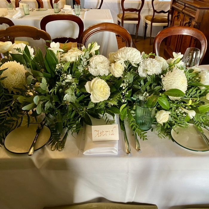 White rose and chrysanthemum garland along a table